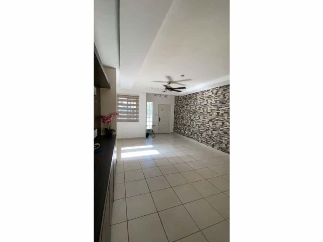 Living area with tiled floors, accent wall, ceiling fan in PH Victoria House