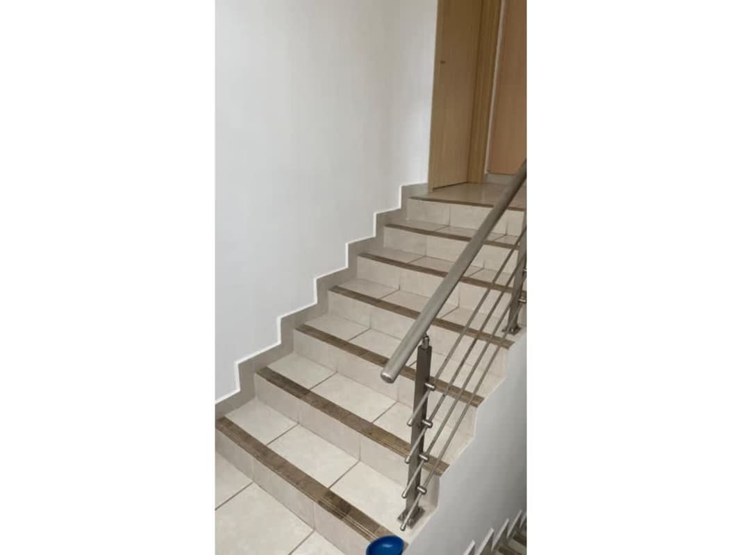 Modern staircase with metal handrail and tiled steps PH Victoria Panama house