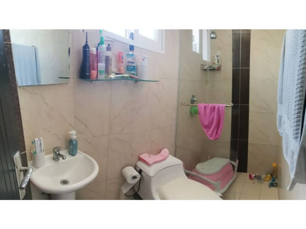 Modern open-plan living and dining area with glass table blue chairs tiled floor PH Valy Tower Carrasquilla Panama