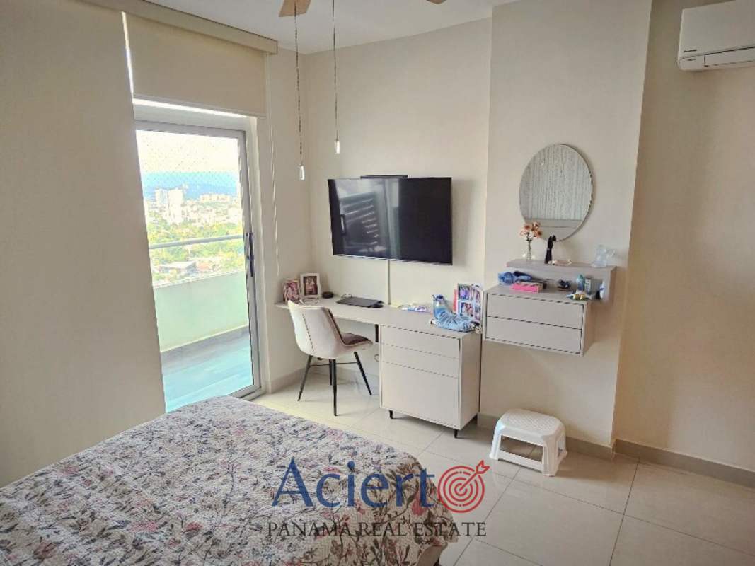 Bedroom with balcony, desk, and panoramic views in PH Coral Tower Panama City