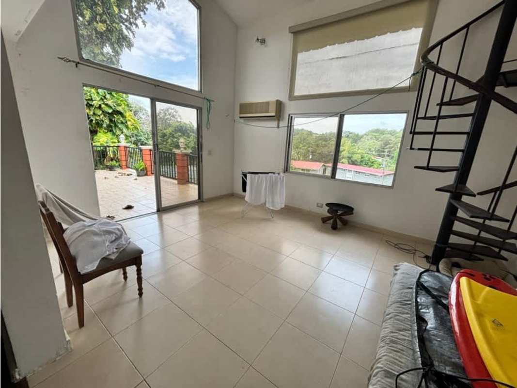 Living area with double-height ceilings large windows spiral staircase Embassy Village Clayton Panama