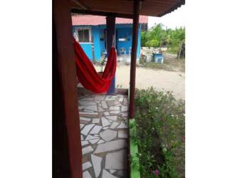 Covered porch area with hammock garden and blue house on Pocri beach property
