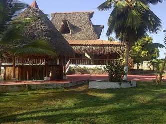 Rustic beach bar and restaurant building with tropical palapa roof near ocean in Río Hato Panama
