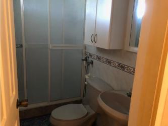 Traditional bathroom with enclosed shower, tiled walls in Coronado beach house Panama