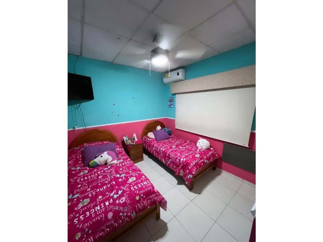 Bedroom with teal accent wall, AC unit, desk, ceiling fan in Panama City house