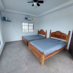 Bedroom with two beds, AC, ceiling fan, and tile floor in Palmeras del Golf Coronado