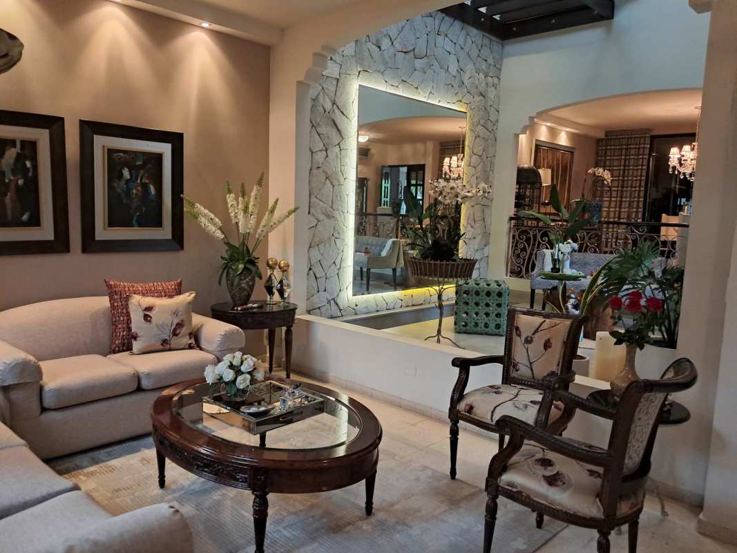 Luxury living room with exposed beams, stone walls, Mediterranean decor, lush plants Panama City