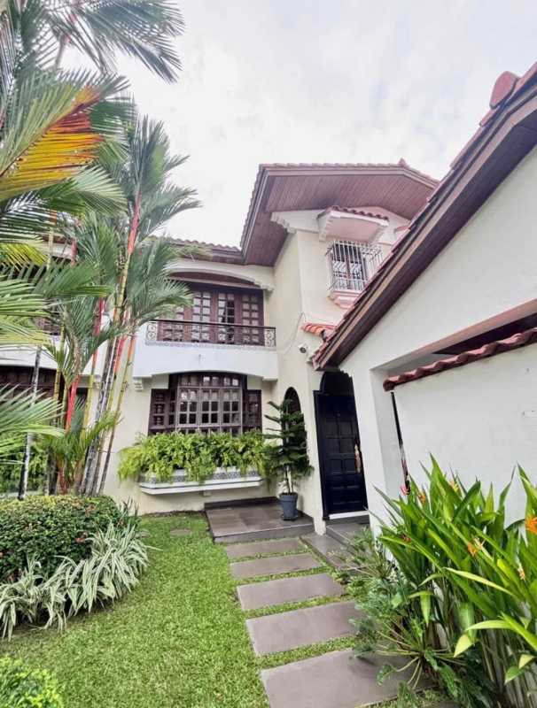 Kidney-shaped swimming pool with tropical landscaping, brick deck and terrace in Panama City luxury house