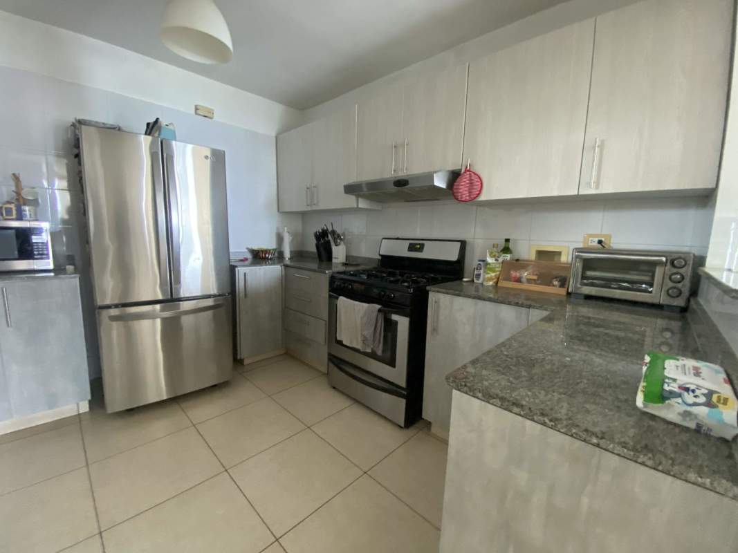 Semi-open kitchen with granite countertops stainless steel appliances at PH Costa View Costa del Este Panama City