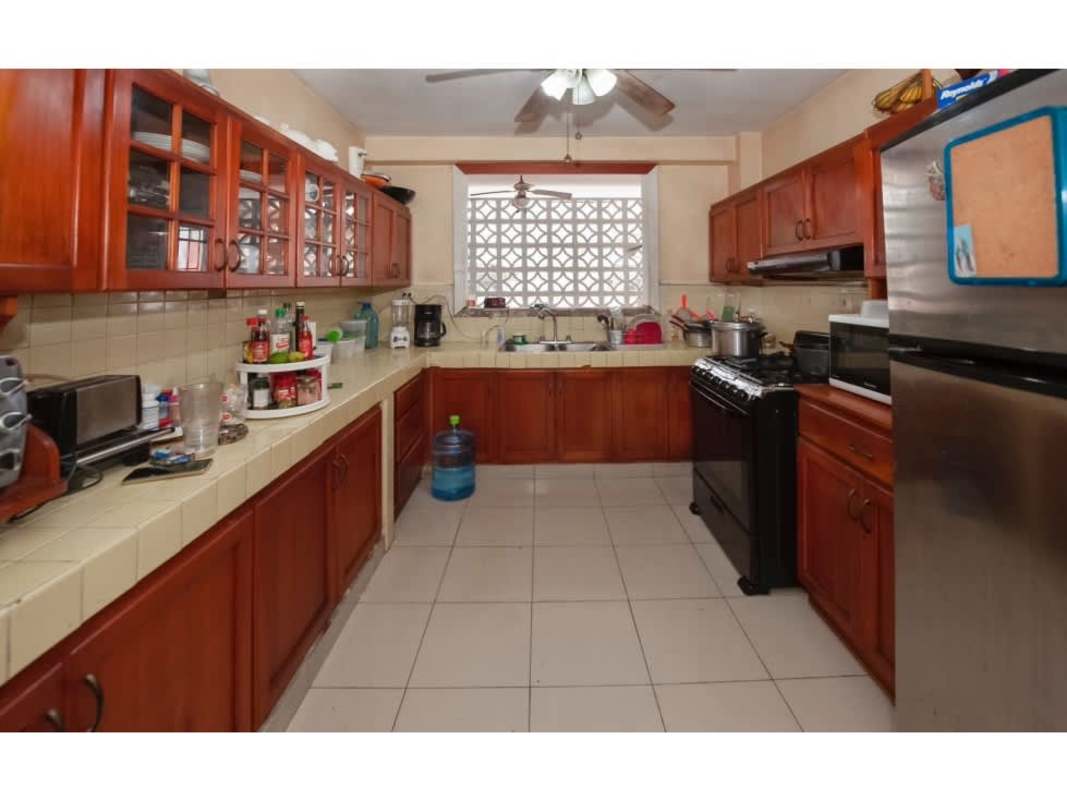 Traditional kitchen with double sink, wood cabinets, tiled counters and natural light in PH Continental Tower El Cangrejo Panama