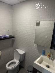 Modern white tiled restroom with mirror inside commercial office Costa Verde Panama