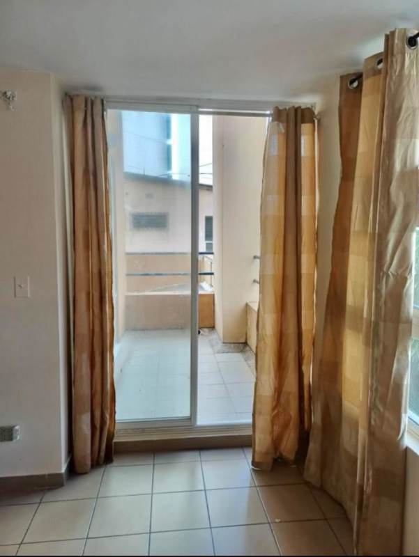 Bedroom featuring sliding glass door to balcony, beige curtains and tiled floors PH Terrazas de San Francisco Panama