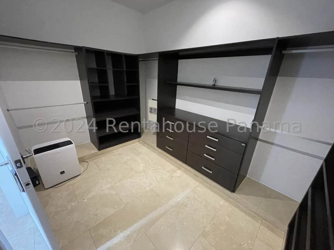 Modern walk-in closet with built-in wood shelving and drawers in luxury Fairway Estate mansion Santa Maria