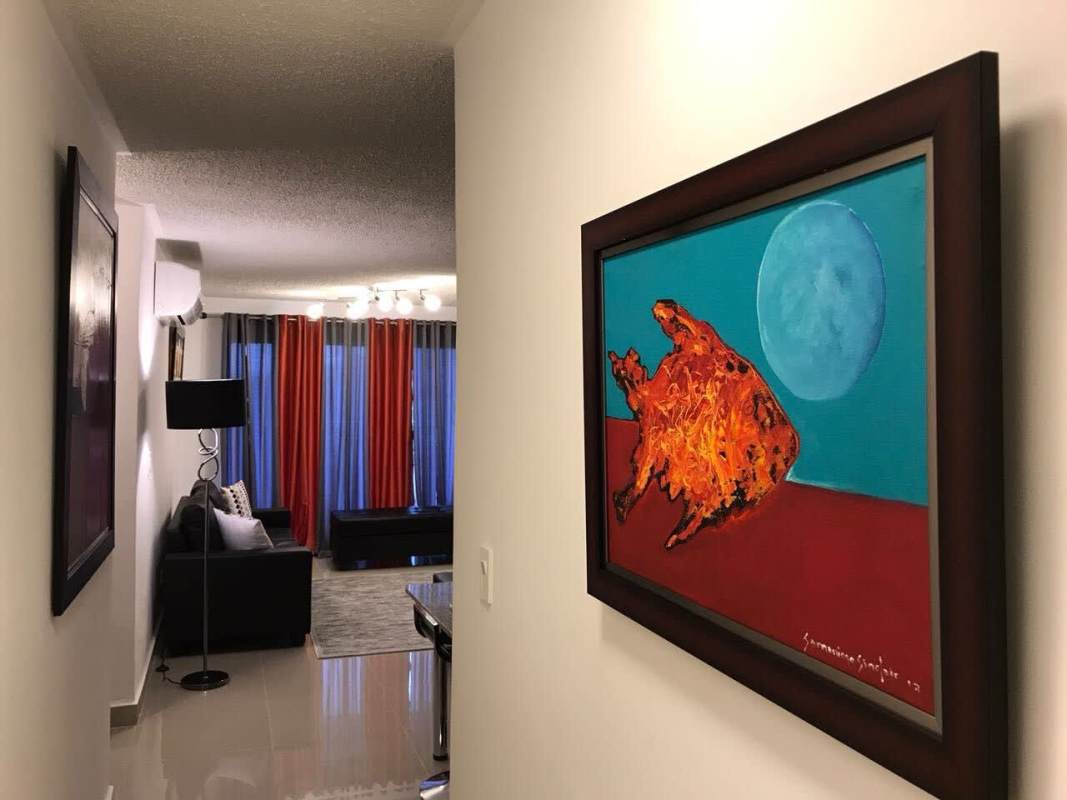 Open living area with hallway, vibrant curtains, black sofa and wall art in Altamira Gardens Panama