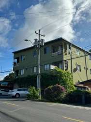 Green and white multi-story hotel or apartment building with balconies for sale in Penonomé Panama