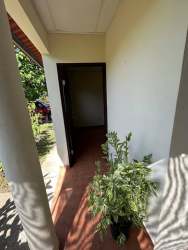Covered entrance porch with column and plants at affordable apartment Villa Nelis Santiago Panama
