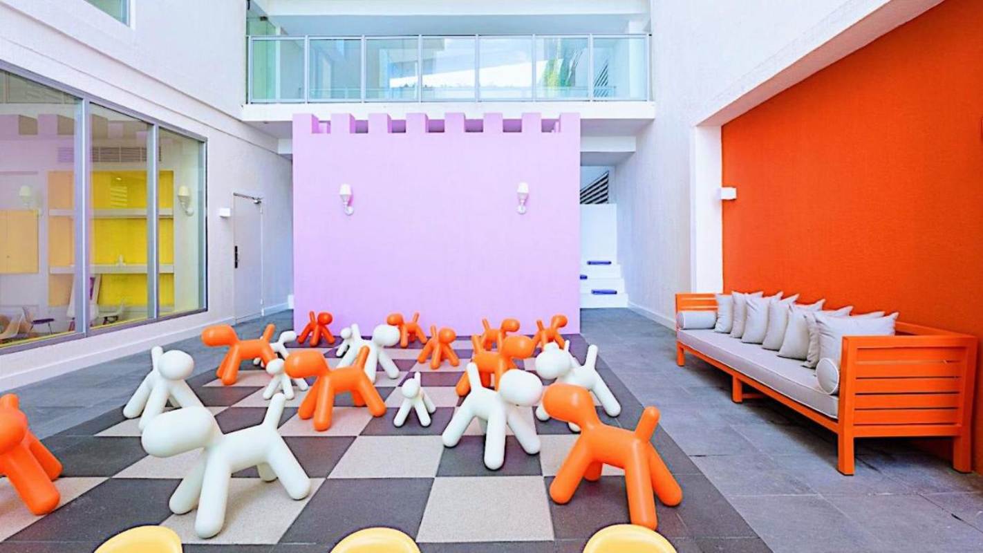 Glass arch entrance surrounded by tropical landscaping PH YOO Avenida Balboa Panama