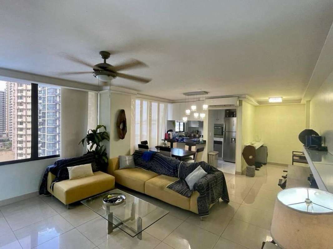 Open-plan living dining space with panoramic windows and contemporary furniture in Paitilla apartment