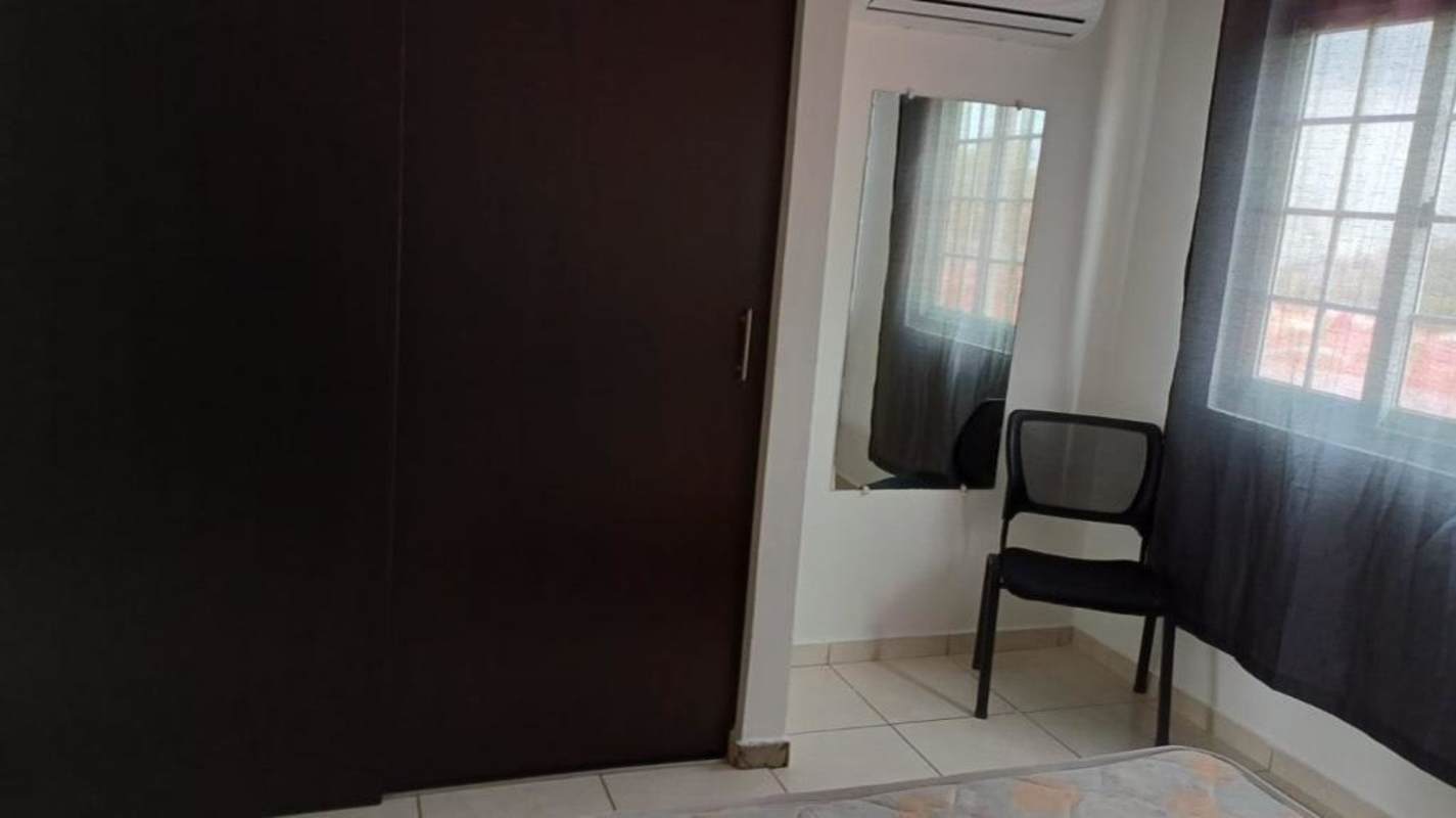 Bedroom with air conditioning, large dark wardrobe, and window in Villa Lucre Panama City