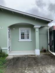 Light green facade with porch arched entry and driveway Urbanización Valle Dorado Panama