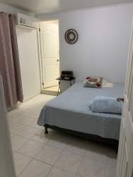 Simple bedroom with tile flooring and closet curtain in Valle Dorado house La Chorrera Panama