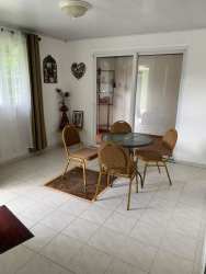 Dining area with glass-top table, sliding glass doors and bright light at Valle Dorado Panama