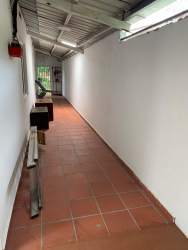 Long covered hallway with terracotta flooring and natural lighting at Valle Dorado home Panama