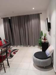 Modern living area with sofa, bar-height dining set, TV and decor Playa Corona Residences Panama