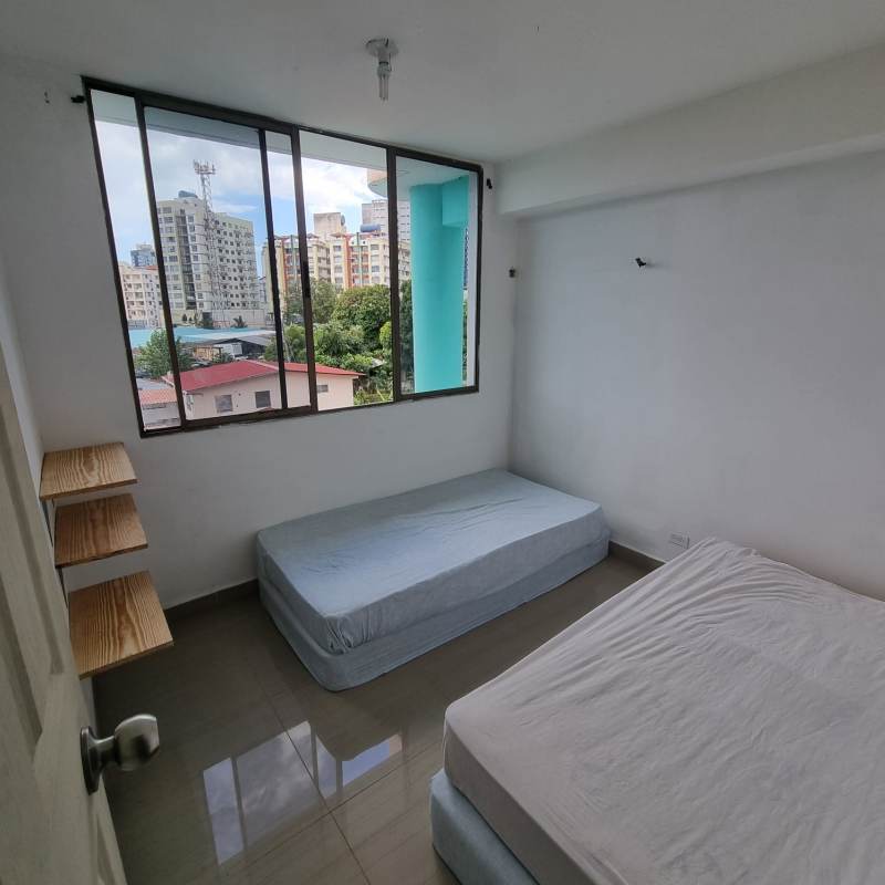 Minimalist bedroom with twin mattresses and large window city view at PH Parque Lefevre Panama City rental