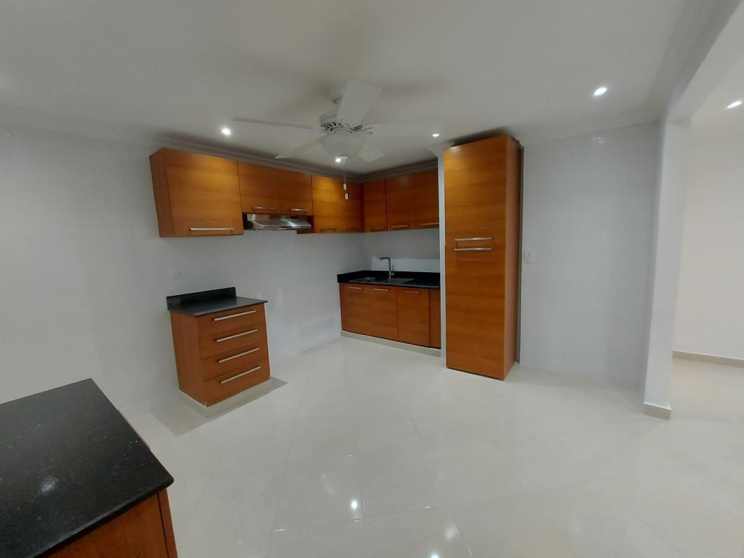Kitchen in rental duplex with granite countertops, wood cabinets, and ceiling fan in Campo Lindbergh Panama