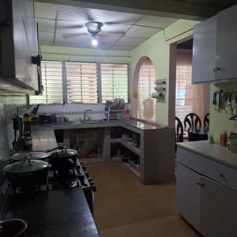 Covered patio with exercise equipment, storage bins and garden view in Villa Lucre house Panama