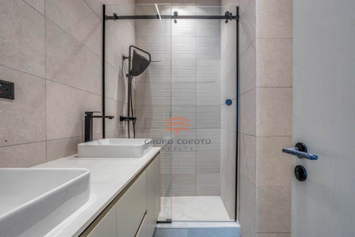 Modern bathroom with glass-enclosed shower, dual vessel sinks, matte black fixtures in PH Grand Tower Punta Paitilla Panama