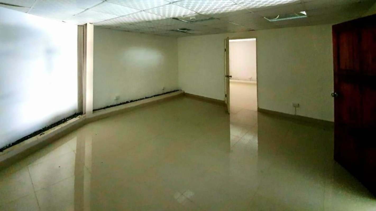 Empty commercial room with neutral tile floor, white walls and drop ceiling Panama City