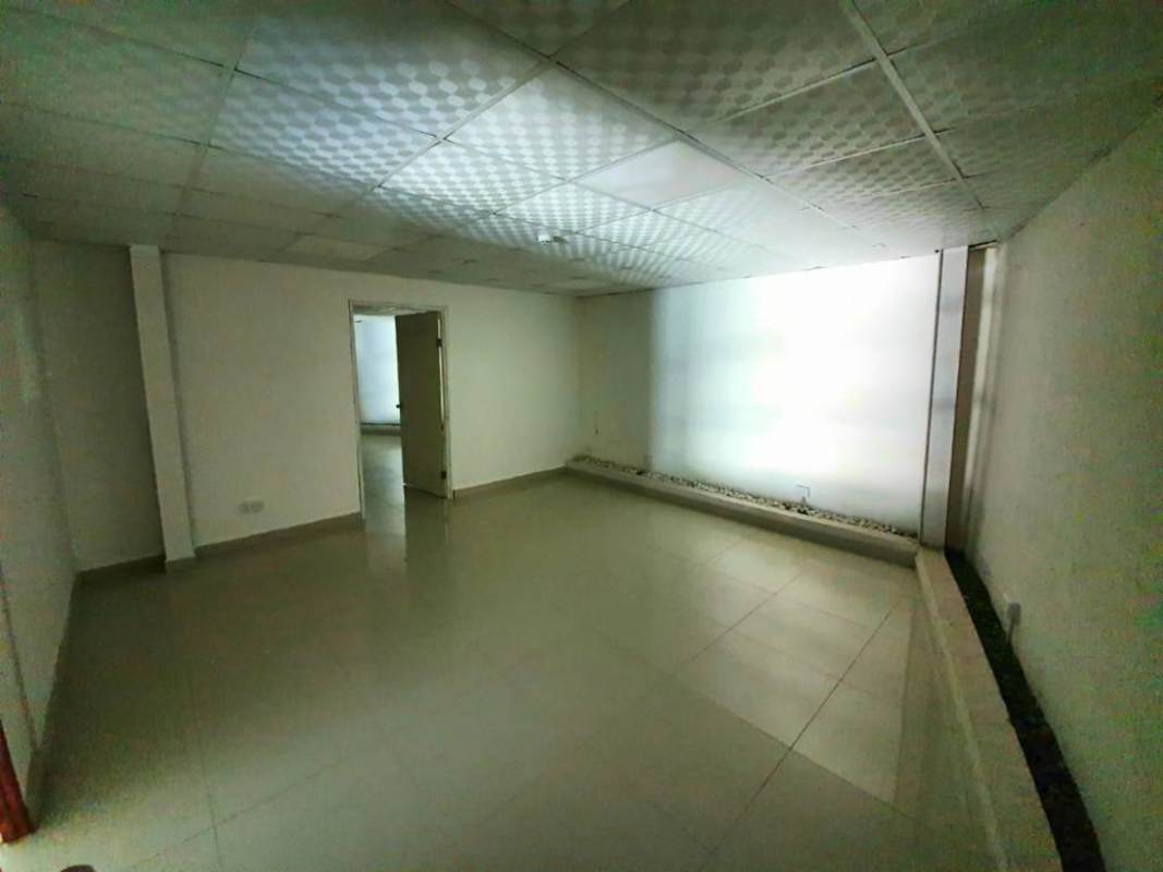 Empty modern office area within warehouse with drop ceiling and glass wall in logistics park