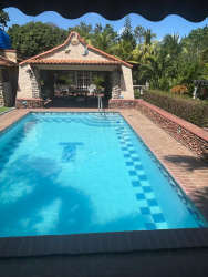Bedroom with sliding glass doors, blue curtains, rustic dresser and patio view at Playa Malibu Panama rental