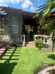 Covered outdoor patio with terracotta tiles, dining set, pergola and potted plants in Playa Malibu rental Panama