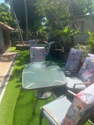 Swimming pool with brick patio, terracotta roof house, and gardens in Playa Malibu rental Panama