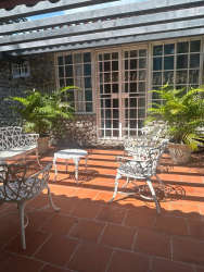 Spacious bedroom with bunk beds, armchair, ceiling fan, AC unit and orange curtains Playa Malibu Panama beach house