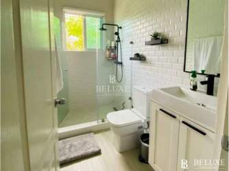Minimalist white subway tile bathroom with glass walk-in shower PH Rodman Bijao Beach Panama