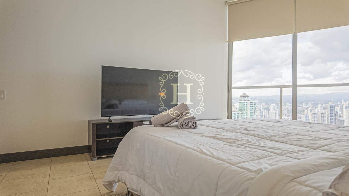 Bedroom with large windows and ocean scenery at The Ocean Club Punta Pacifica