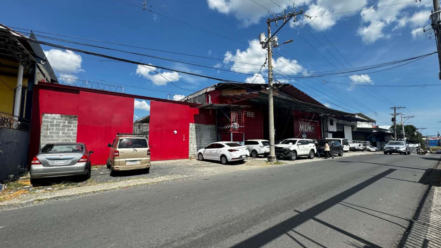 Outdoor concrete yard with metal-roofed loading dock in an industrial warehouse complex Panama City
