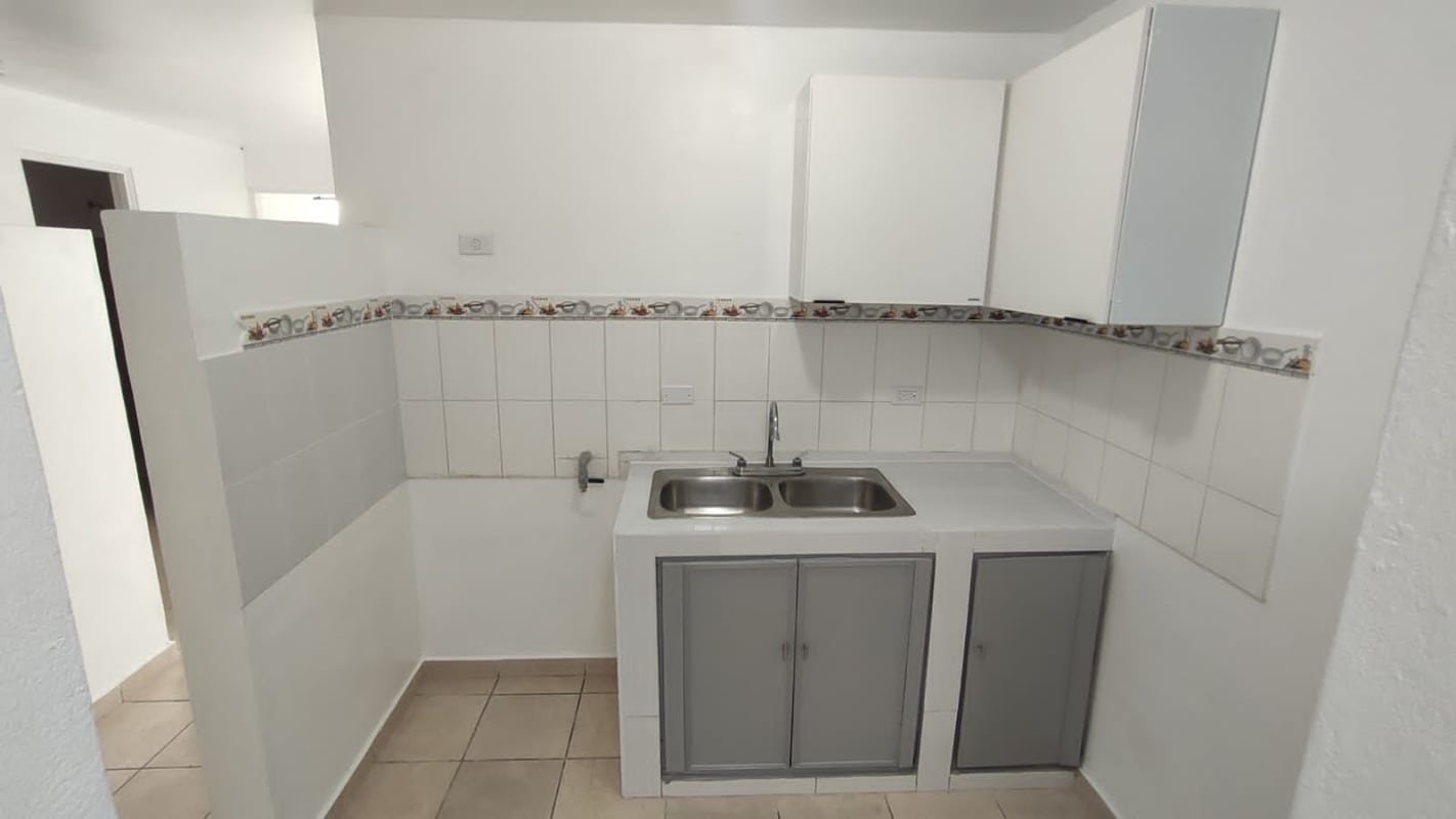Minimalist compact kitchen with white tiles double sink Panama rental apartment