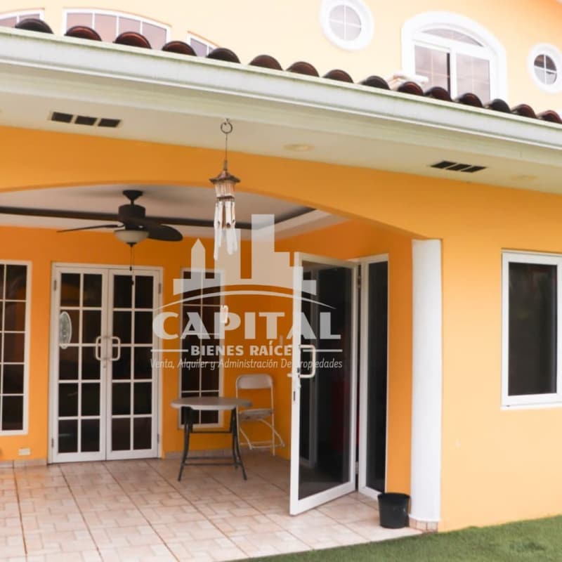 Yellow Mediterranean style home with arched patio, tile roof, glass doors, and covered outdoor space at Rainforest Villas