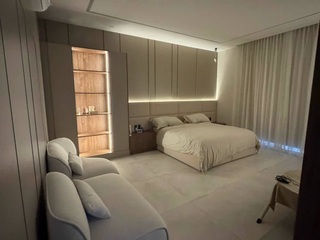 Modern bedroom with built-in shelves, accent lighting, soft neutral decor in The Woods Santa Maria luxury house rental