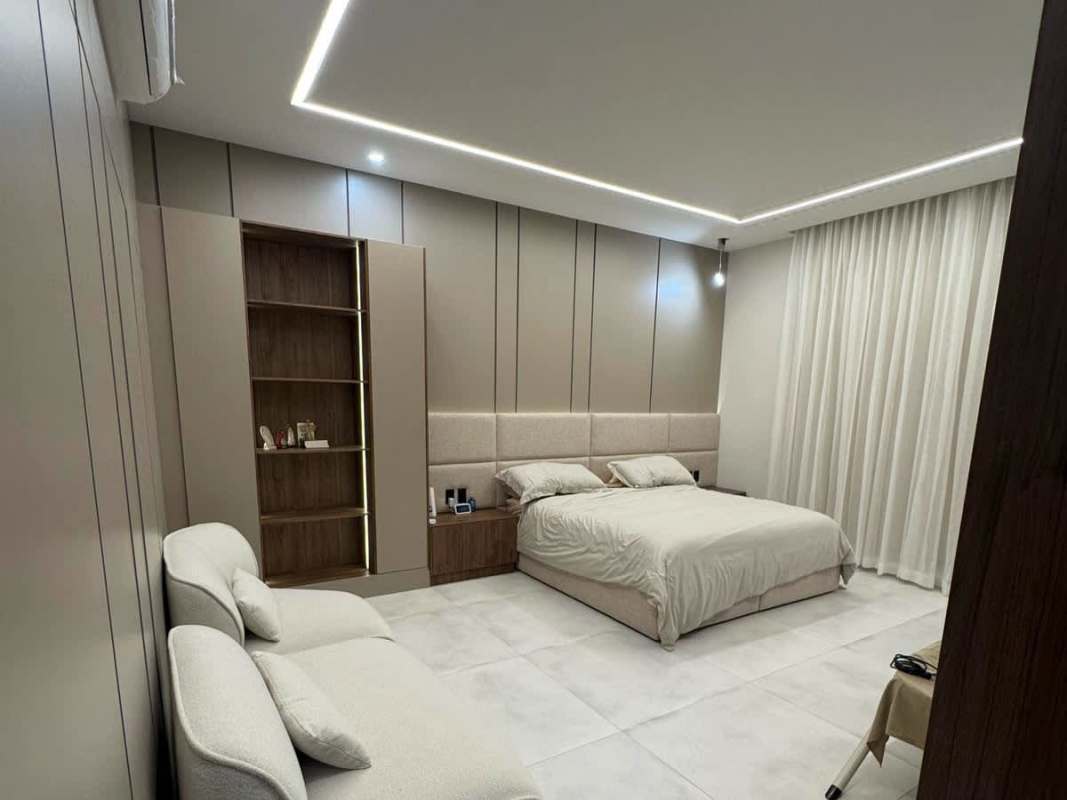 Grand bedroom with upholstered headboard, built-in shelves and soft lighting in The Woods Santa Maria luxury house for rent