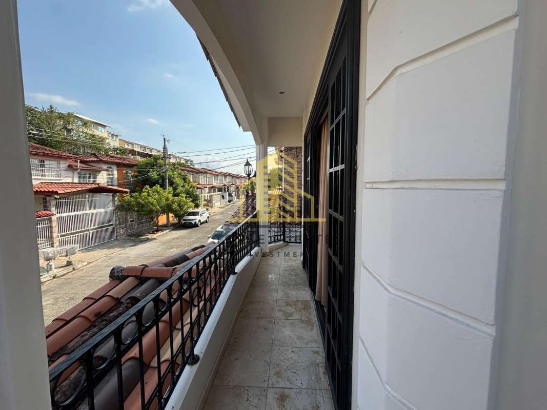 Balcony street view iron railing arch opening rooftops Brisas del Golf Panama