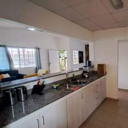 Living area with accent stone wall and mounted TV in house for sale Las Verdes Arraiján