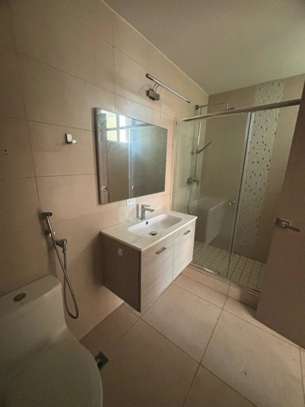 Modern living room with floor-to-ceiling windows and city skyline views in Costa del Este apartment