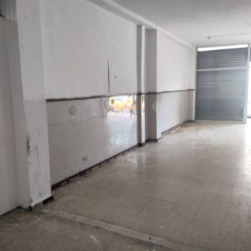 Empty mixed-use unfinished commercial space with tile walls metal rollup in Los Angeles Panama City