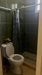 Small bathroom with green tiles walk-in shower pedestal sink El Nazareno duplex La Chorrera Panama